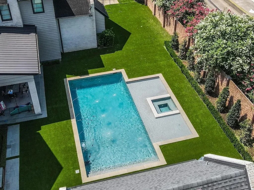 a backyard pool design with artificial turf
